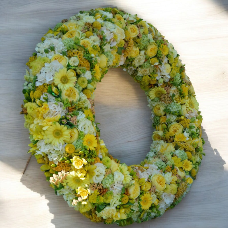 Corona fiorita lutto con fiori pastello
