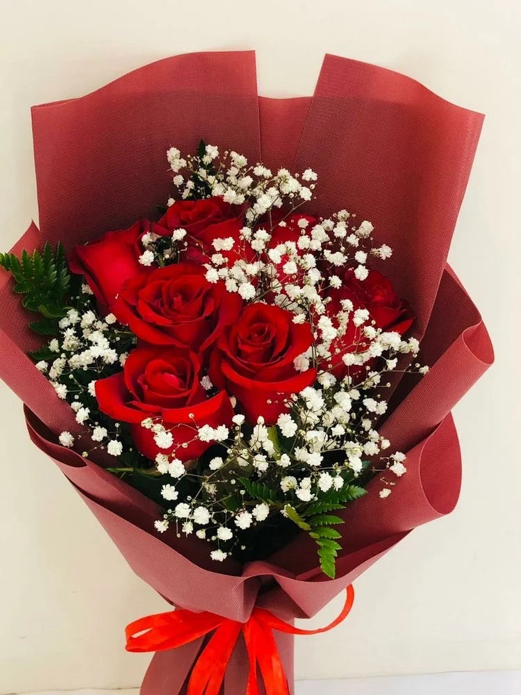 Bouquet di 7 rose con gipsofila e verde decorativo e incarto rosso