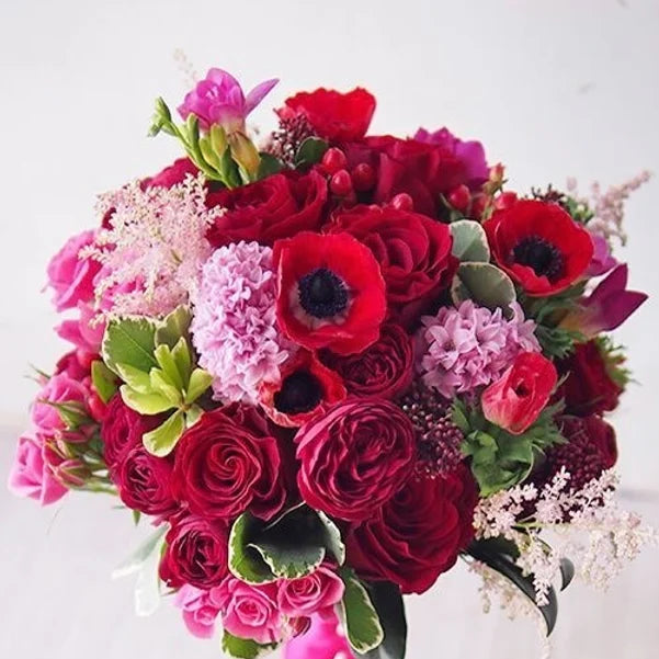 Bouquet di rose, anemoni, giacinti, fresia e verde decorativo