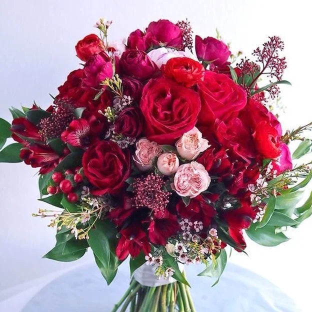 Bouquet di rose, roselline, alstroemeria, wax, iperico, skimmia e verde decorativo